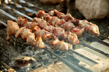 Kebabs outdoors on a homemade grill, with a shallow depth of field
