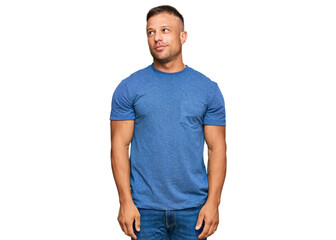 Fototapeta premium Handsome muscle man wearing casual clothes smiling looking to the side and staring away thinking.