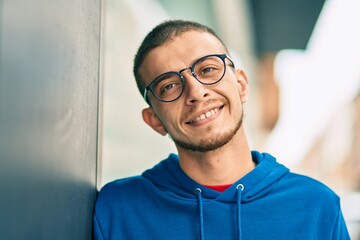 Young hispanic man smiling happy standing at the city.