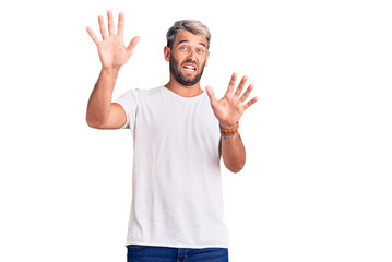 Young handsome blond man wearing casual t-shirt smiling with hands on chest with closed eyes and grateful gesture on face. health concept.