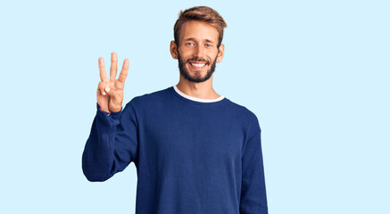 Handsome blond man with beard wearing casual sweater showing and pointing up with fingers number three while smiling confident and happy.