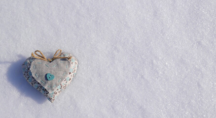 Nature photo cute fabric heart on white snow