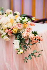 floral arrangement of fresh flowers on the table of the newlyweds of white, pink and peach roses