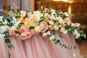 floral arrangement of fresh flowers on the table of the newlyweds of white, pink and peach roses