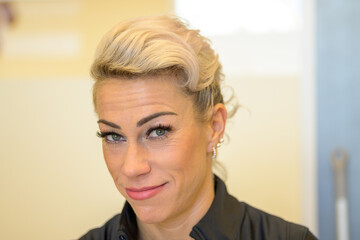 Smiling middle-aged blond woman wearing false eyelashes