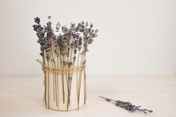 Dry natural lavender decorating large candles on white background.
