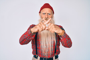 Old senior man with grey hair and long beard wearing hipster look with wool cap rejection expression crossing fingers doing negative sign