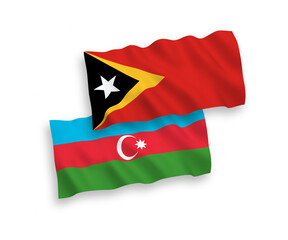 National vector fabric wave flags of East Timor and Azerbaijan isolated on white background. 1 to 2 proportion.