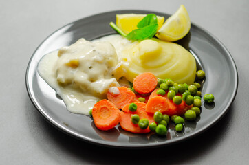 Cod Mornay, flaky cod with a creamy cheese sauce, with mashed potato, peas and carrots