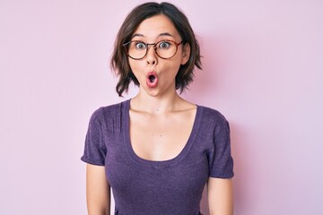 Young beautiful woman wearing casual clothes and glasses scared and amazed with open mouth for surprise, disbelief face