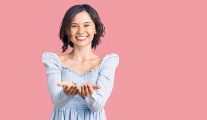 Fototapeta premium Young beautiful girl wearing casual clothes smiling with hands palms together receiving or giving gesture. hold and protection
