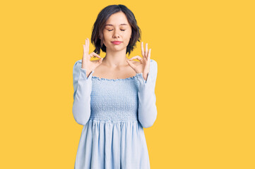 Young beautiful girl wearing casual clothes relaxed and smiling with eyes closed doing meditation gesture with fingers. yoga concept.