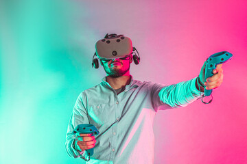 Young man using the virtual reality glasses and two gamepad