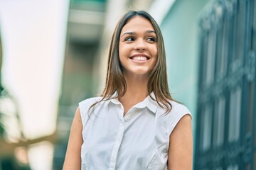 Fototapeta premium Beautiful latin teenager girl smiling happy standing at the city.