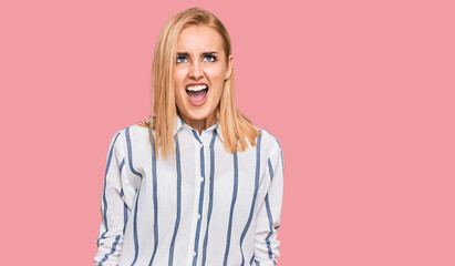 Beautiful caucasian woman wearing casual clothes angry and mad screaming frustrated and furious, shouting with anger. rage and aggressive concept.