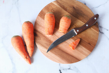 fresh carrots on chopping board on table 