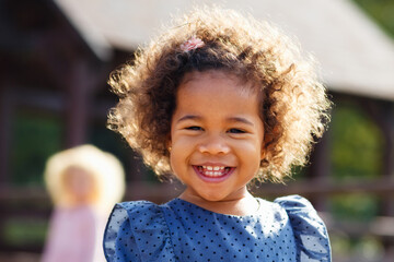 Outdoor close up portrait of a cute young black girl smiling - African American Child