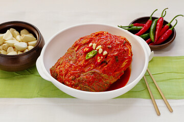 The most famous Korean food Kimchi(napa cabbage), garlic and chili peppers on traditional patchwork background. Front view.
