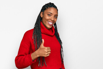 African american woman wearing casual winter sweater doing happy thumbs up gesture with hand. approving expression looking at the camera showing success.