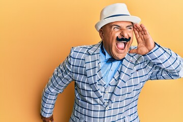 Mature middle east man with mustache wearing vintage and elegant fashion style shouting and screaming loud to side with hand on mouth. communication concept.