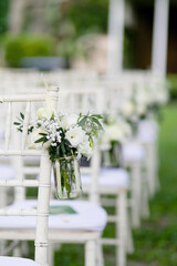 White wedding chair decorated with flowers in the garden