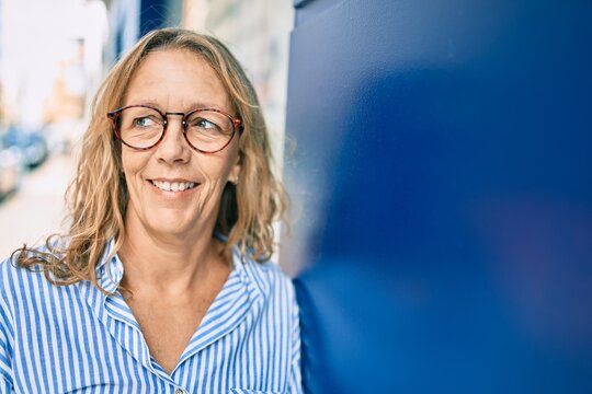 Middle age caucasian woman smiling happy standing at the city.