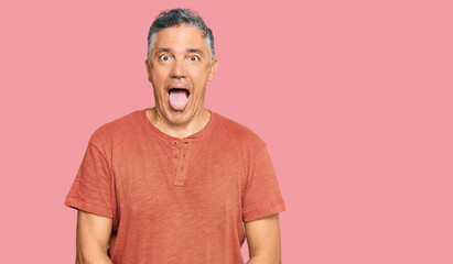 Handsome middle age man wearing casual clothes sticking tongue out happy with funny expression. emotion concept.