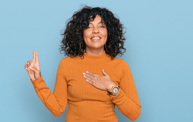 Young hispanic woman wearing casual clothes smiling swearing with hand on chest and fingers up,...