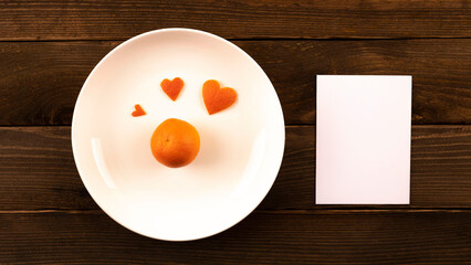 heart made of tangerine peel. postcard, note on a wooden background. gift in a red box
