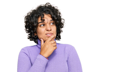 Fototapeta na wymiar Young hispanic woman with curly hair wearing casual clothes thinking worried about a question, concerned and nervous with hand on chin