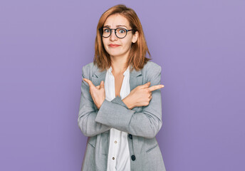 Young caucasian woman wearing business style and glasses pointing to both sides with fingers, different direction disagree