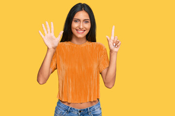 Young brunette arab woman wearing casual clothes showing and pointing up with fingers number seven...