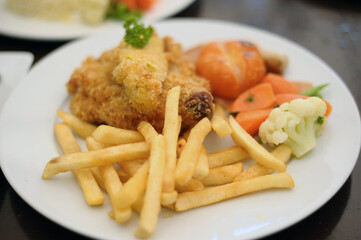 Close up a plate of deep-fried chicken chop with fries and salad. Western food.