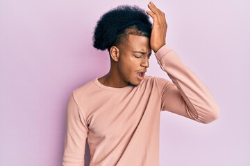African american man with afro hair wearing casual clothes surprised with hand on head for mistake, remember error. forgot, bad memory concept.