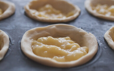 Pastel de nata dough with cream close-up

