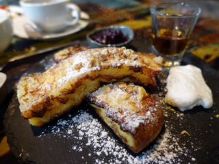 French toast with honey syrup on a black plate