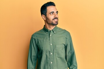 Young hispanic man wearing casual clothes looking to side, relax profile pose with natural face and confident smile.