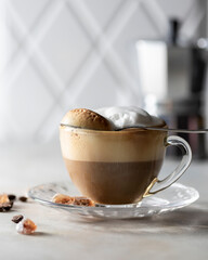 Transparent cup of cappuccino with foam on a white background. Hot latte or cappuccino.