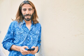 Fototapeta premium Young middle eastern man using smartphone at the city.