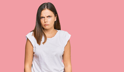 Young caucasian woman wearing casual white tshirt skeptic and nervous, frowning upset because of...