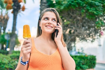Fototapeta premium Young middle east girl talking on the smartphone eating ice cream at the city.