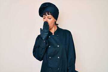 Beautiful brunettte woman wearing professional cook uniform bored yawning tired covering mouth with hand. restless and sleepiness.