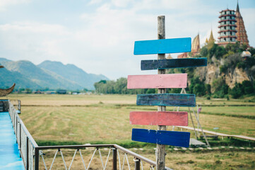 Road signs multicolored old wooden arrows on nature and mountain background.