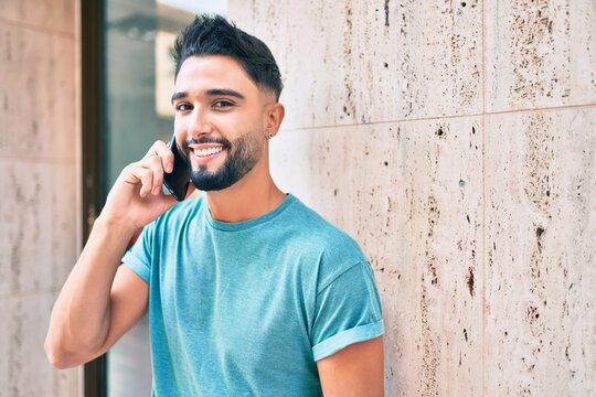 Young arab man with serious expression talking on the smartphone at the city.