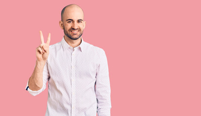 Young handsome man wearing elegant shirt showing and pointing up with fingers number two while smiling confident and happy.