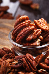 Composition with a bowl of shelled pecan nuts. Delicacies