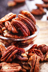 Composition with a bowl of shelled pecan nuts. Delicacies