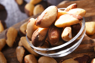 Composition with a bowl of shelled brazil nuts. Delicacies