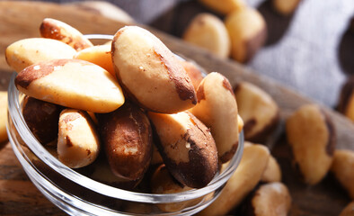 Composition with a bowl of shelled brazil nuts. Delicacies