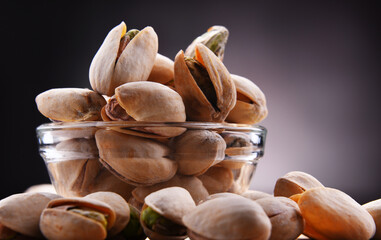 Composition with bowl of in shell pistachios. Delicacies